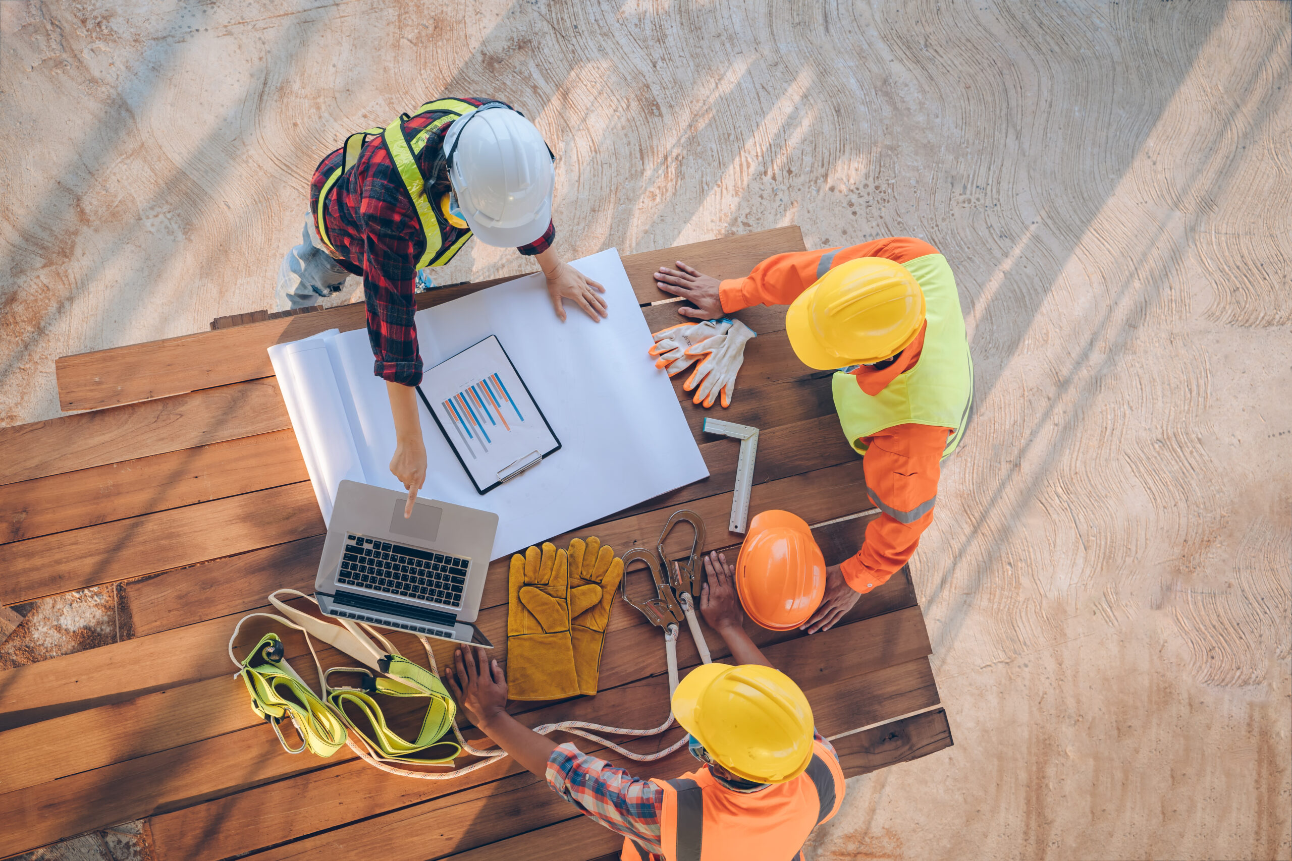 Team of engineer and architects working, meeting, discussing,des Three construction workers look at a laptop on the worksite.