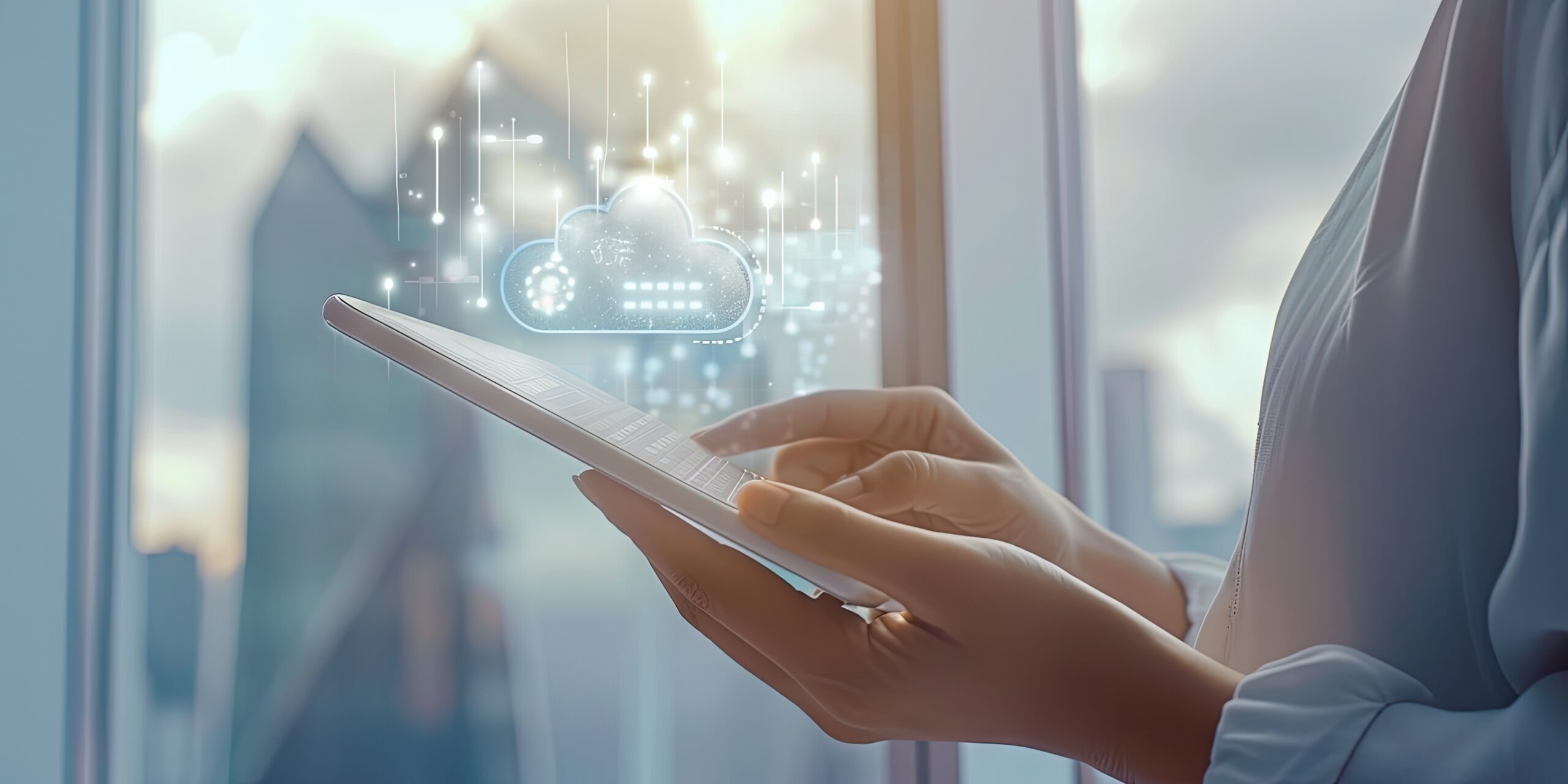 A professional uses a smart tablet in front of a large window with a view of a city skyline.